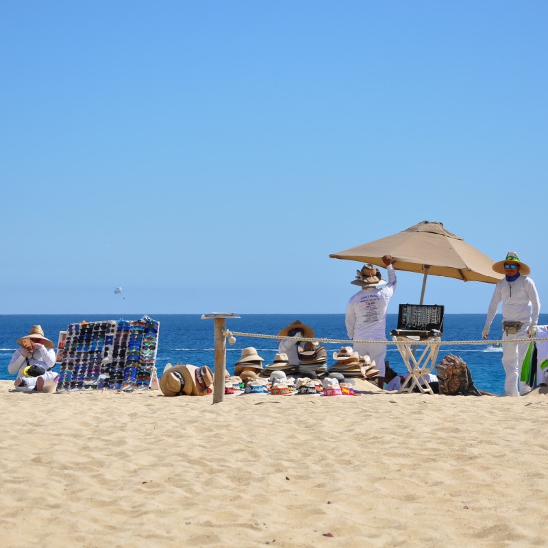 Cabo Beach Vendors with the sand and the sea in the background.