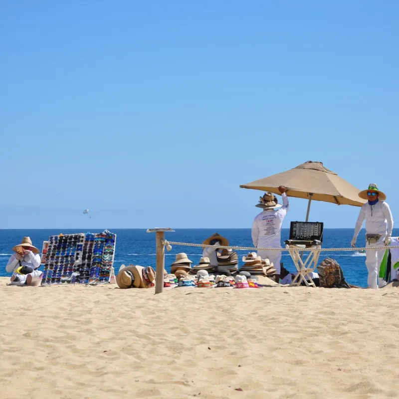 Cabo Beach Vendors with the sand and the sea in the background.