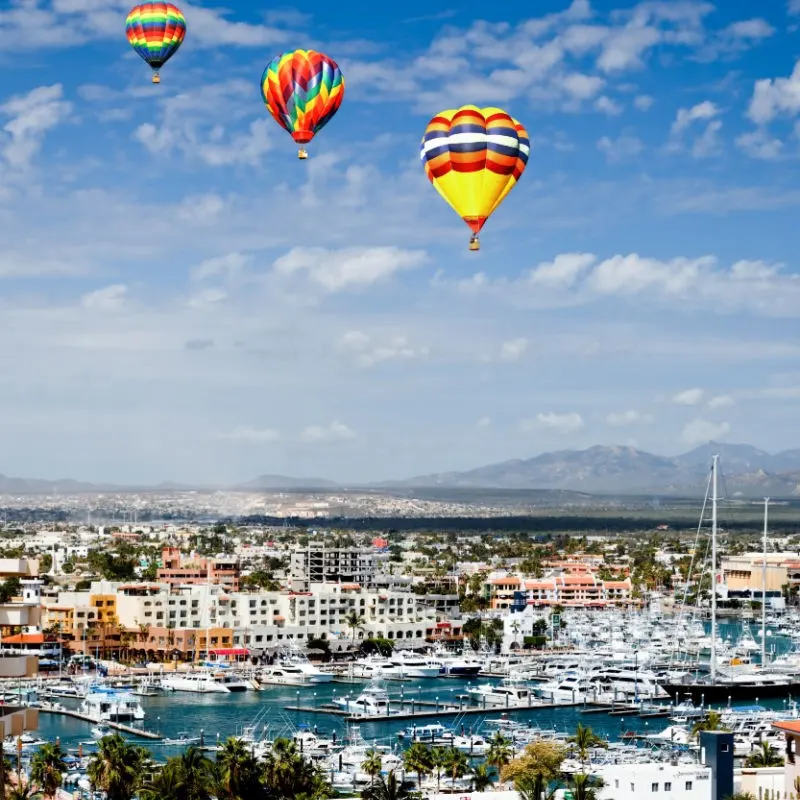Cabo Marina with Hot Air Balloons in the sky and boats in the marina.