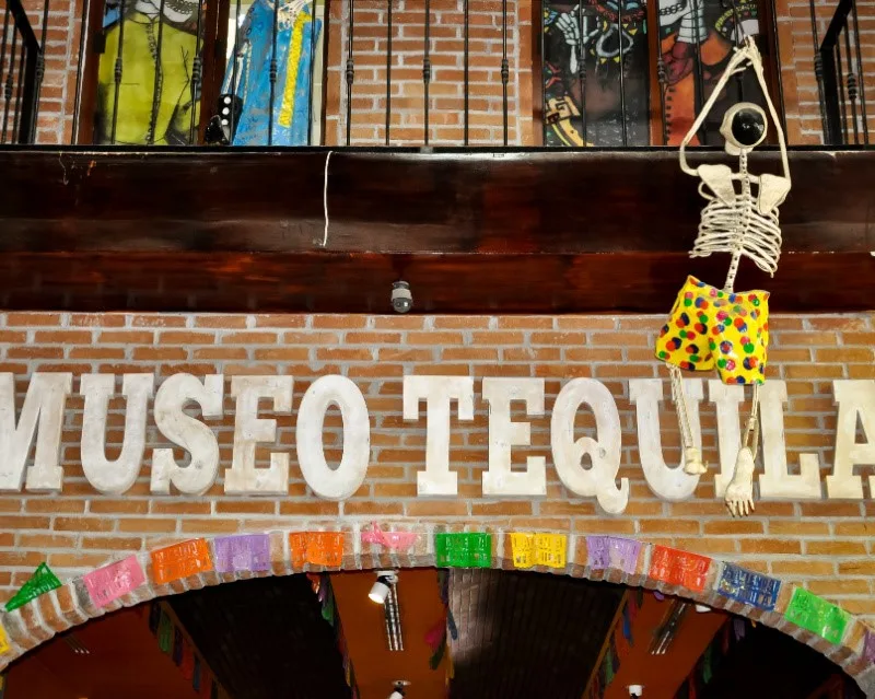 Cabo Tequila Museum with an artificial skeleton hanging from the building.
