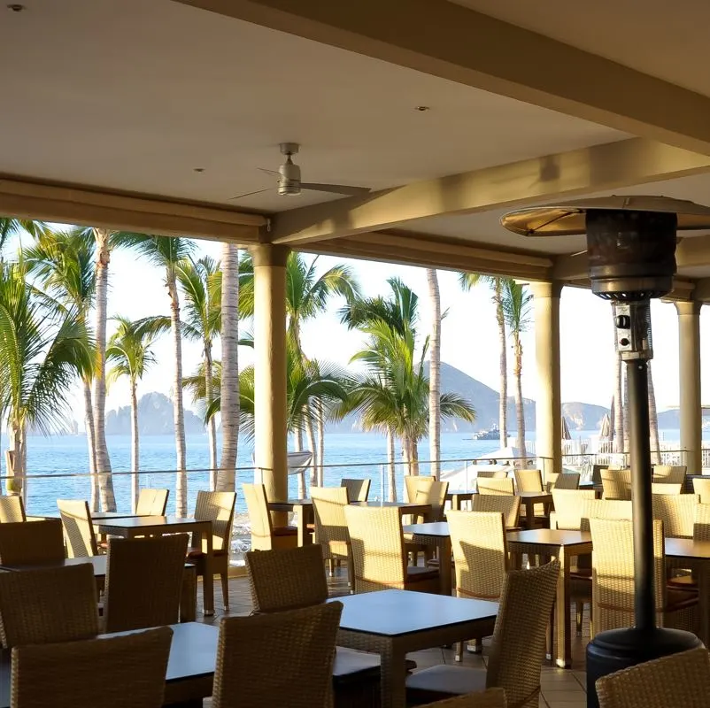 Los Cabos Empty outdoor seating at a restaurant with ocean and mountains in the background