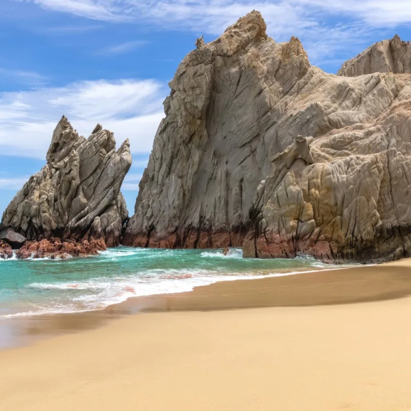 A secluded Lover's Beach with large rocks in the background, los cabos