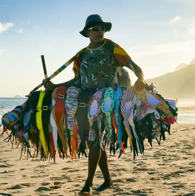 Man selling all sorts of swimwear merchendise on the beach