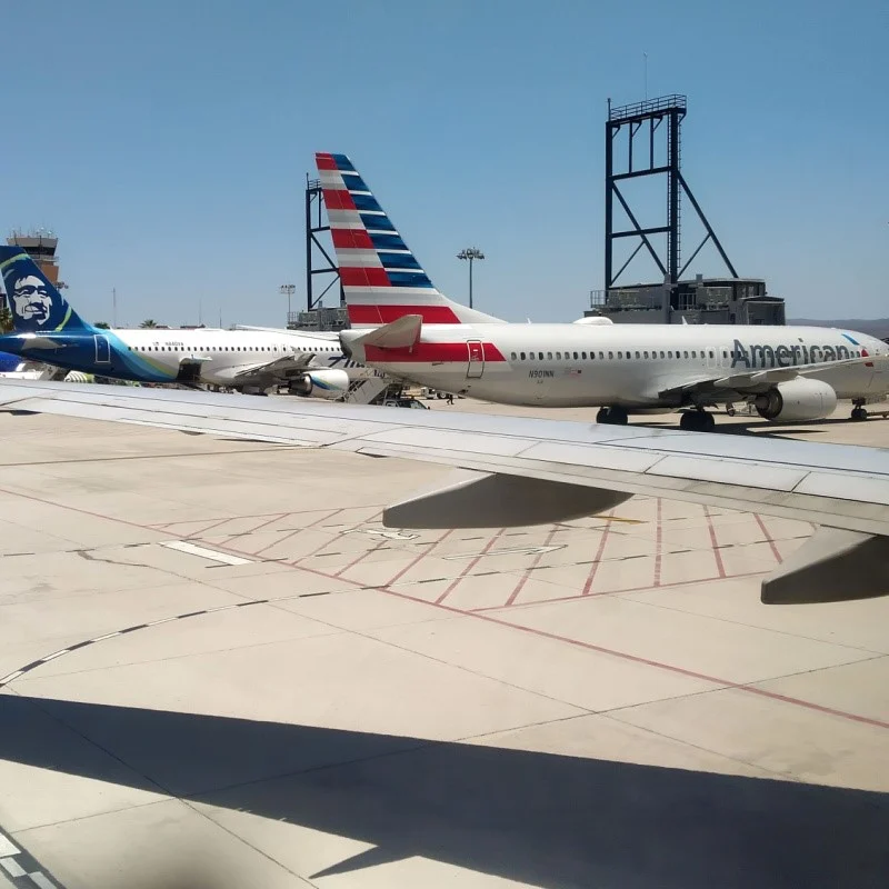 Multiple Planes in Cabo on the tarmac waiting to take -off on a sunny day.