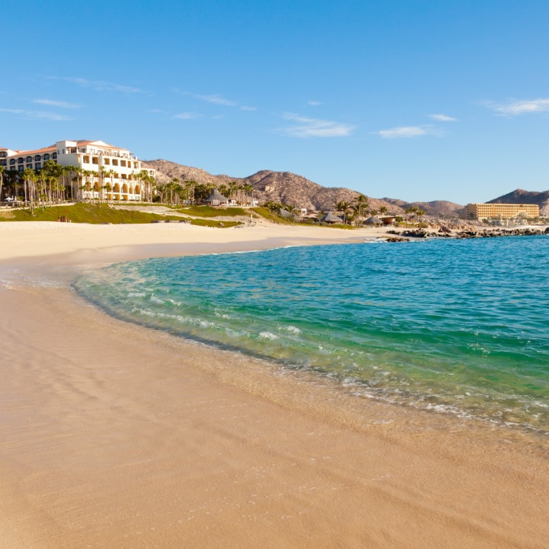 Resorts on a Los Cabos Beach with sand and turquoise water.