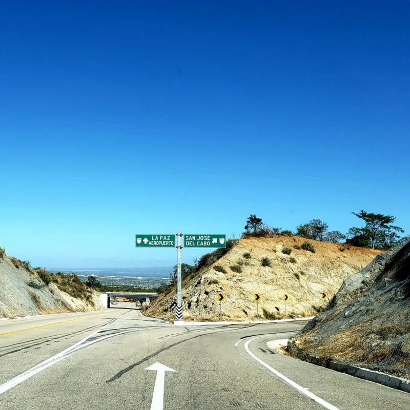 Road to San Jose del Cabo with a sign also pointing toward La Paz.