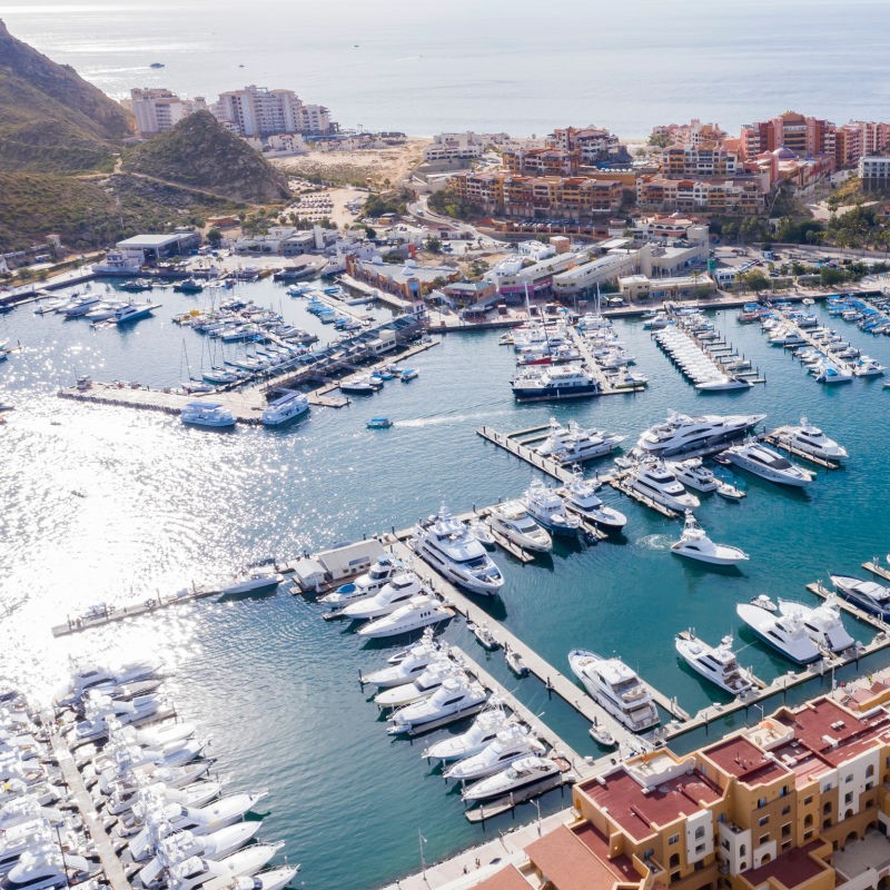 Cabo San Lucas Marina filled with boats and surrounded by buildings.