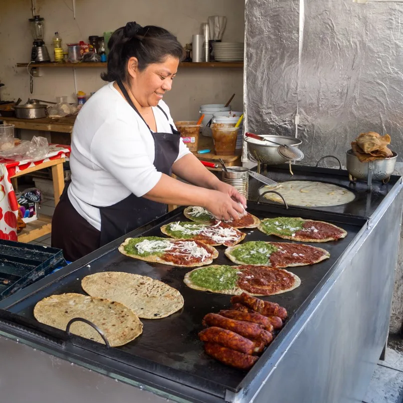 Street food vendor preparing Mexican food outdoors.