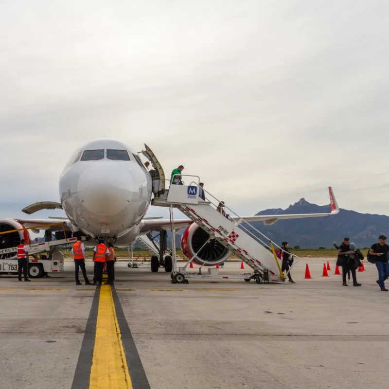 Tourists Getting Off a Plane n the tarmac in Los Cabos at Los Cabos International Airport.