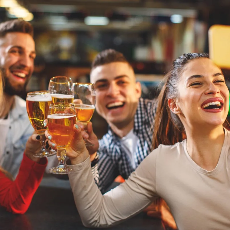 2 guys and a girl toasting with alcohol