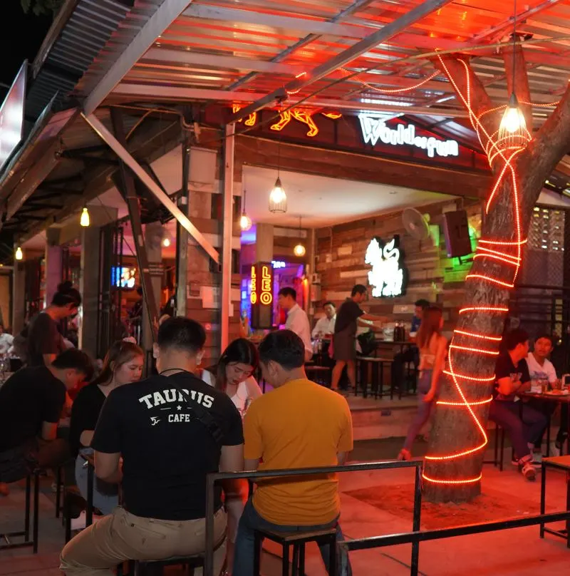 People at a table outside of a very colorful bar