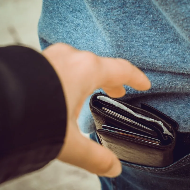 A pickpocket trying to remove someones wallet