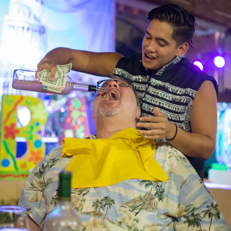 Tourist Having Tequila Poured Down His Throat in Los Cabos