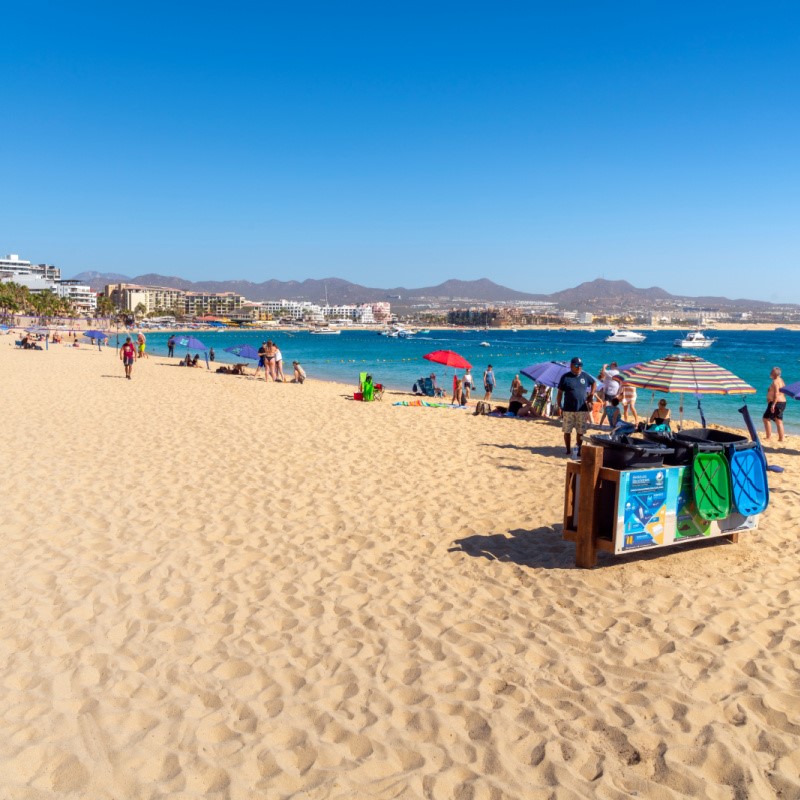 Tourists on a Beach in Cabo San Lucas With Resorts in the Background