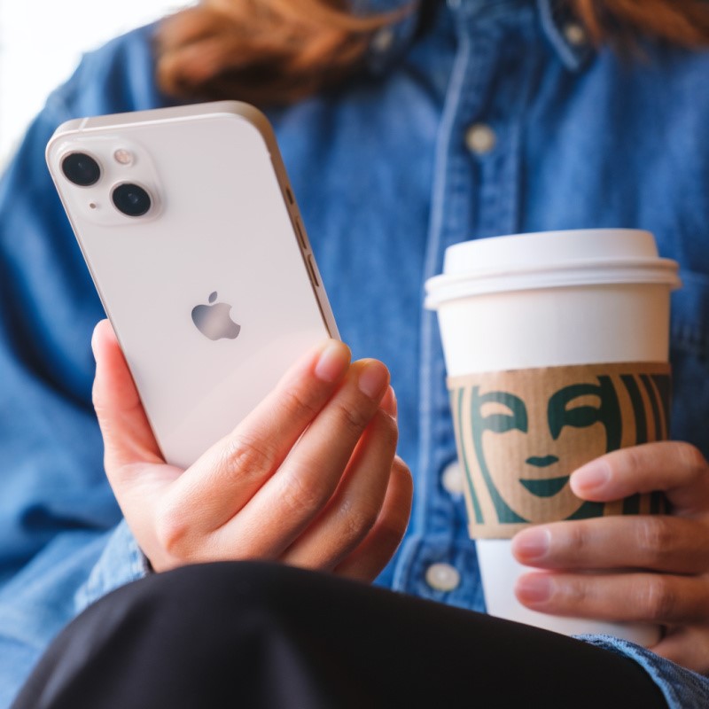 Woman Waiting with a Starbucks Cup and an Iphone