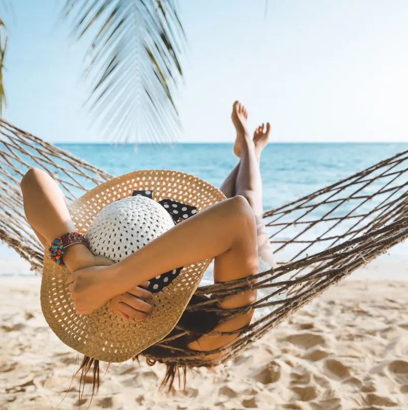 Woman in a hammock looking at the ocean