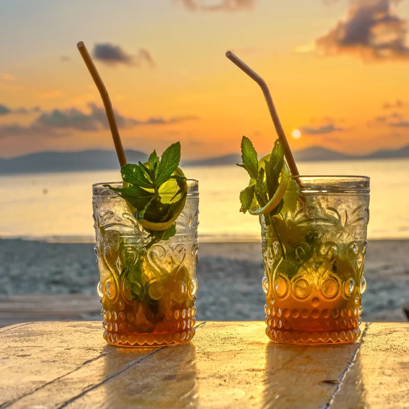 Two cocktail glasses overlooking the beach