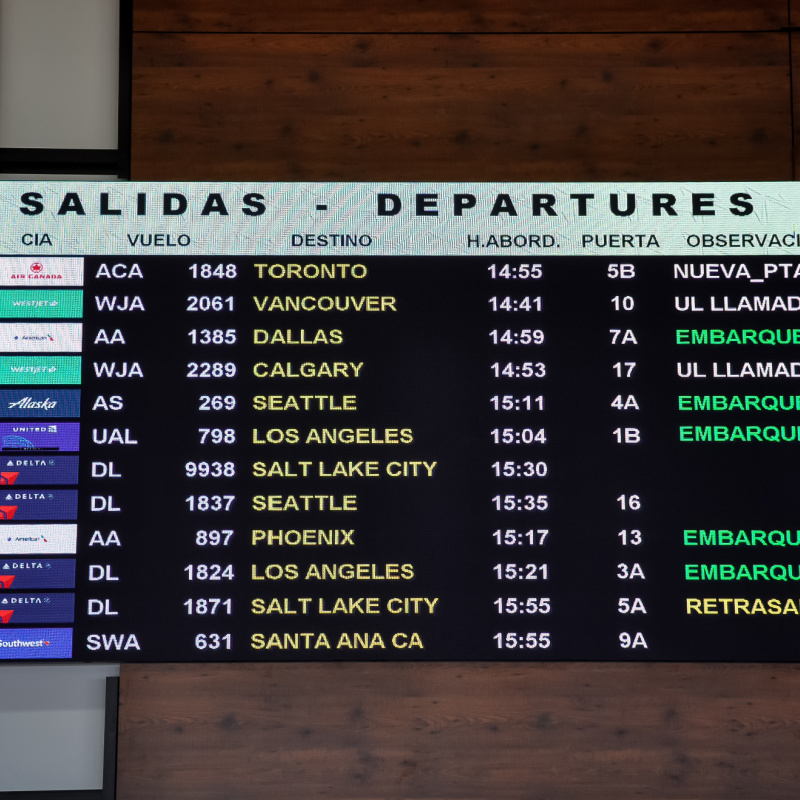 Departures board at Los Cabos International Airport showing flights to US cities