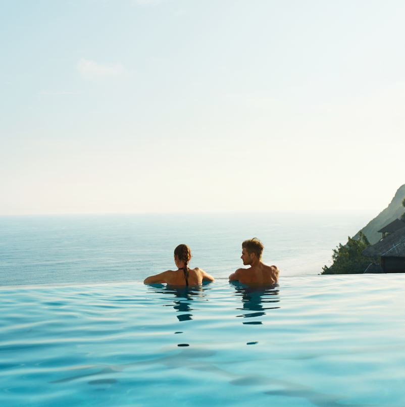 Couple at an infinity pool that overlooks the beach