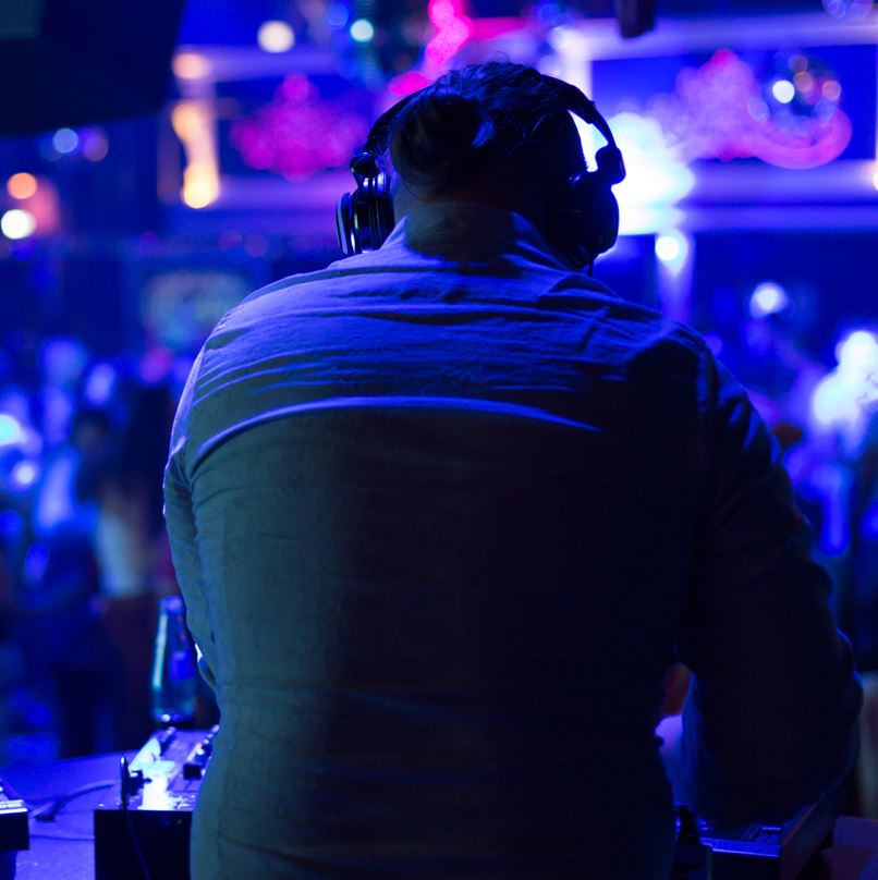 Dj At The Booth With Many People Dancing Inside A Club