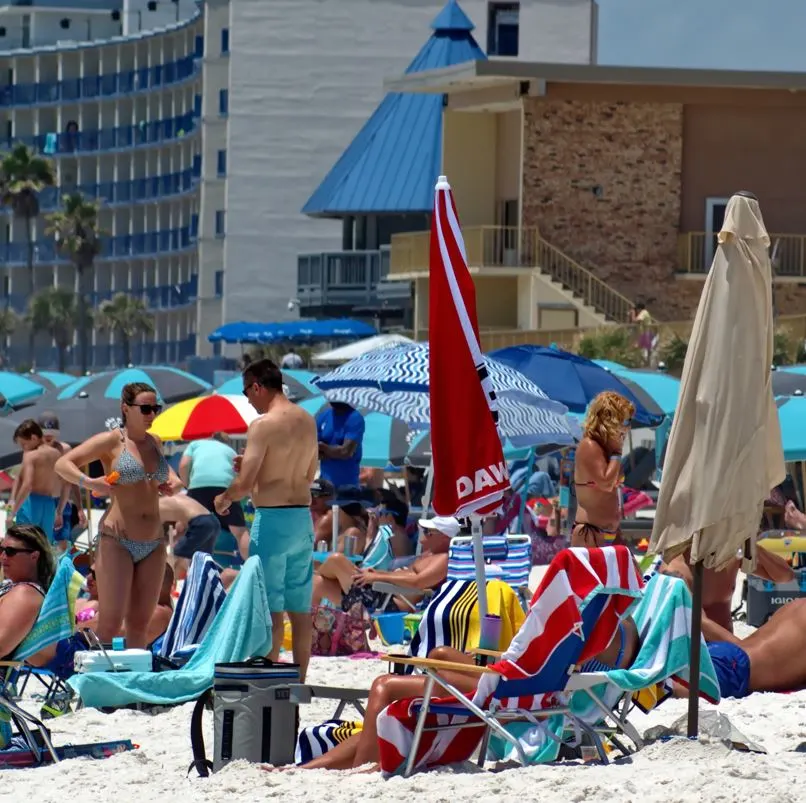 Many people on a beach filled with umbrellas