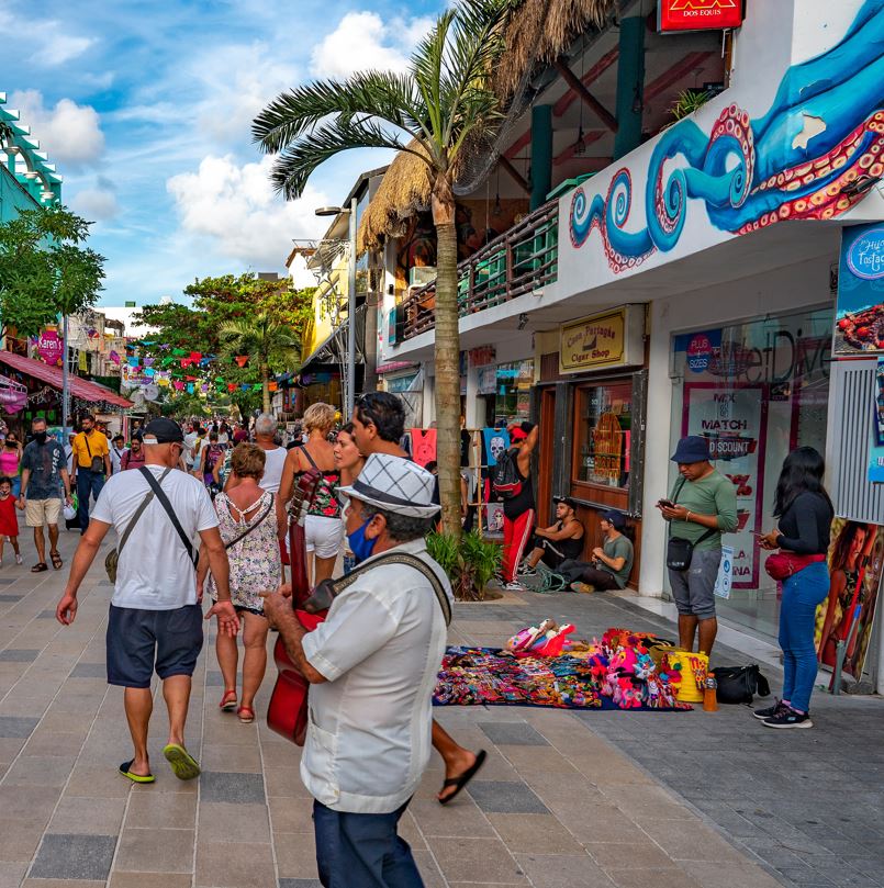 Tourists Walking Through A Busy Mexican Street Filled With Sellers