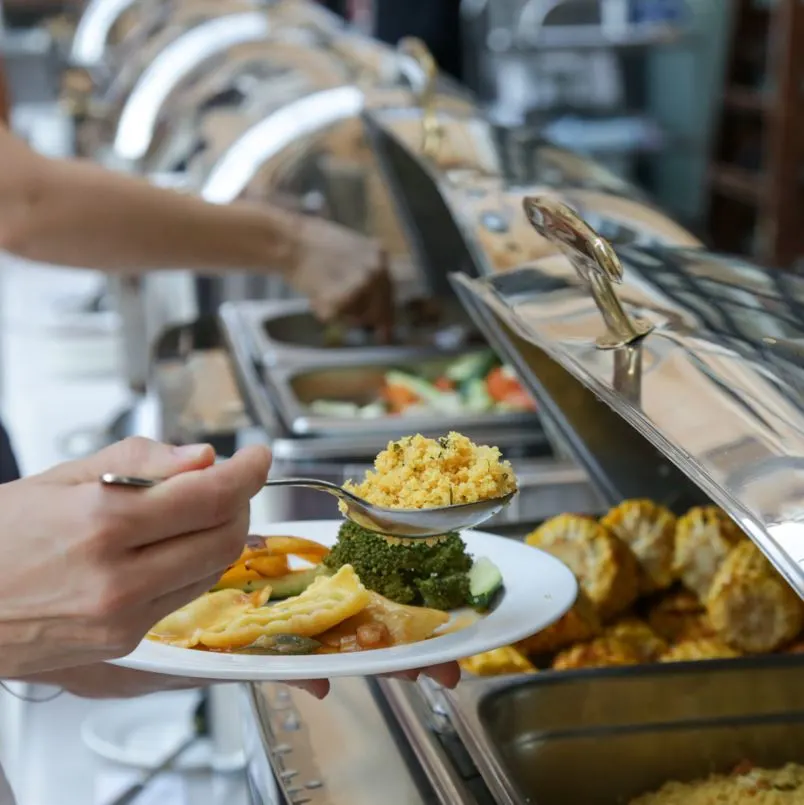 People serving themselves food at a buffet