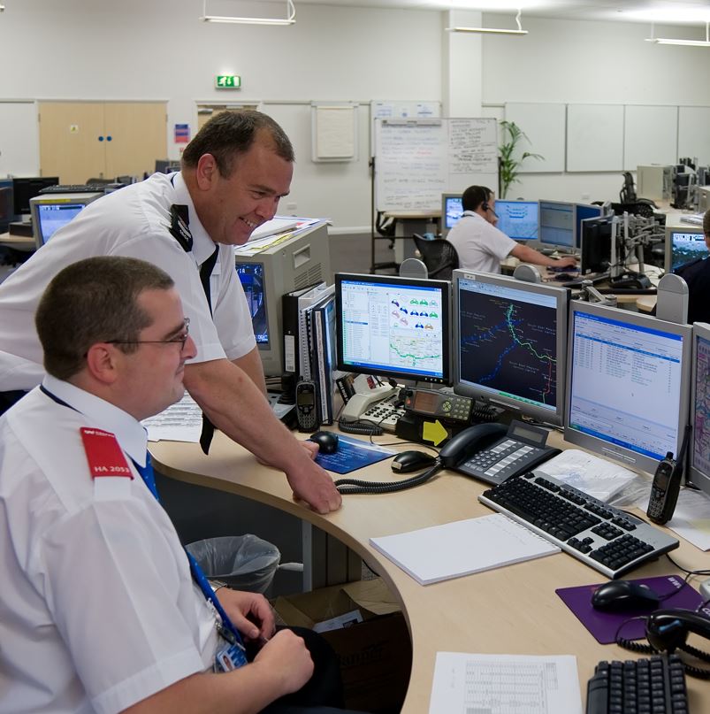 Police Officers Monitoring A Security System At A Station