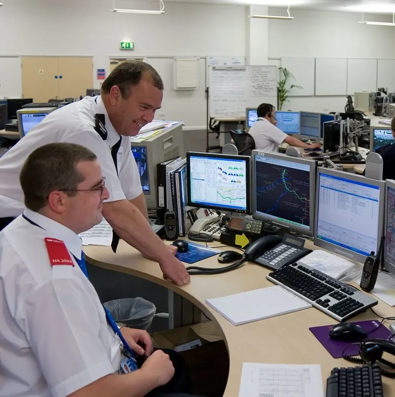 Police Officers Monitoring A Security System At A Station