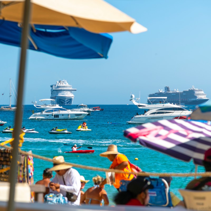 Busy Cabo San Lucas Beach Filled with Tourists and Boats on the Water