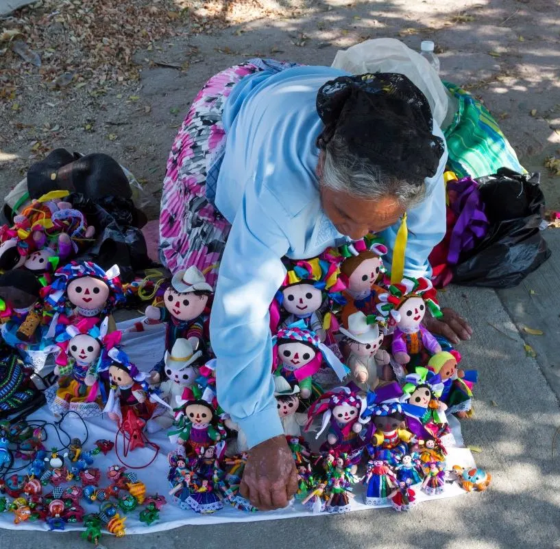 A vendor selling dolls on the beach