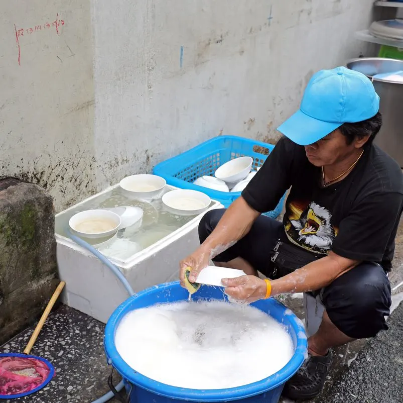 Washing dishes with a tub on the street