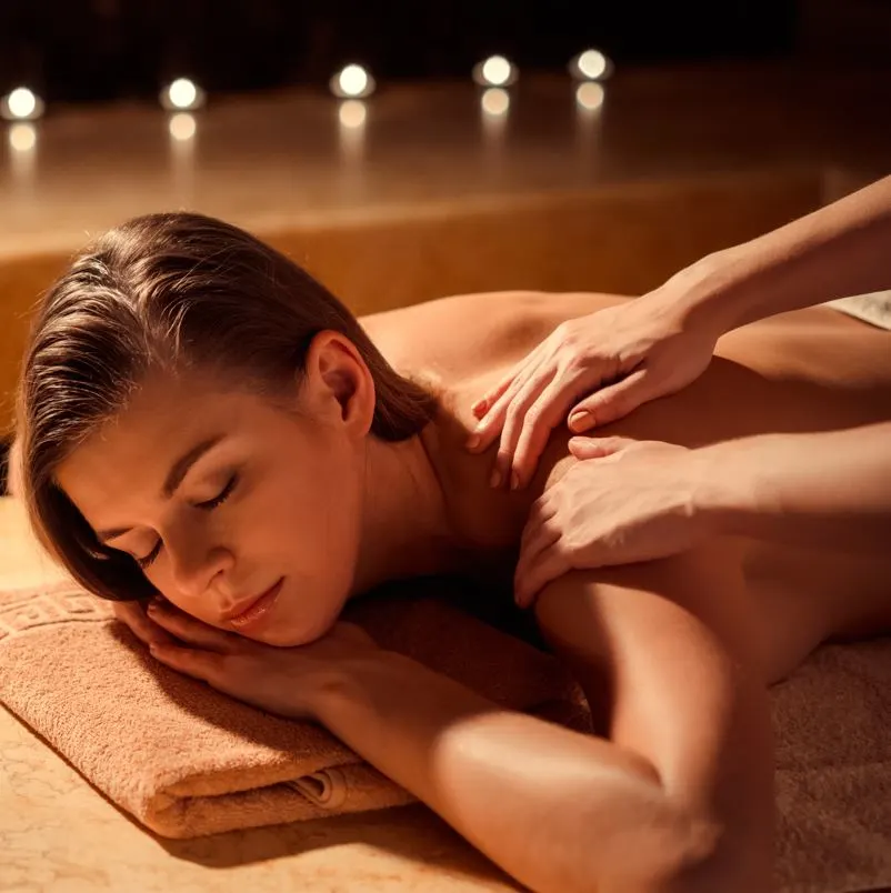 Woman getting a massage in a room full of candles