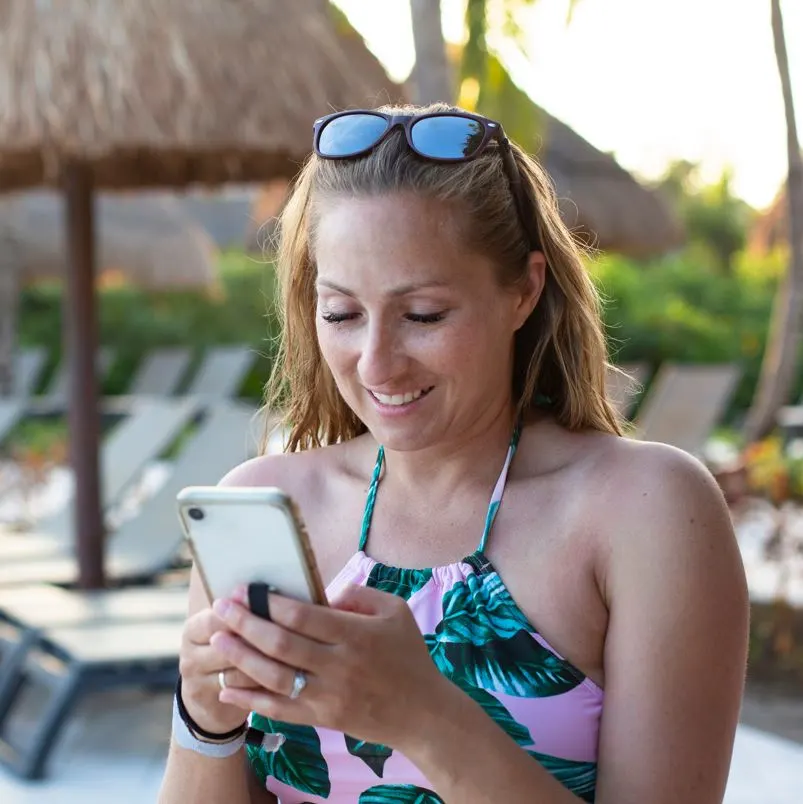 Woman using her phone at a beach resort