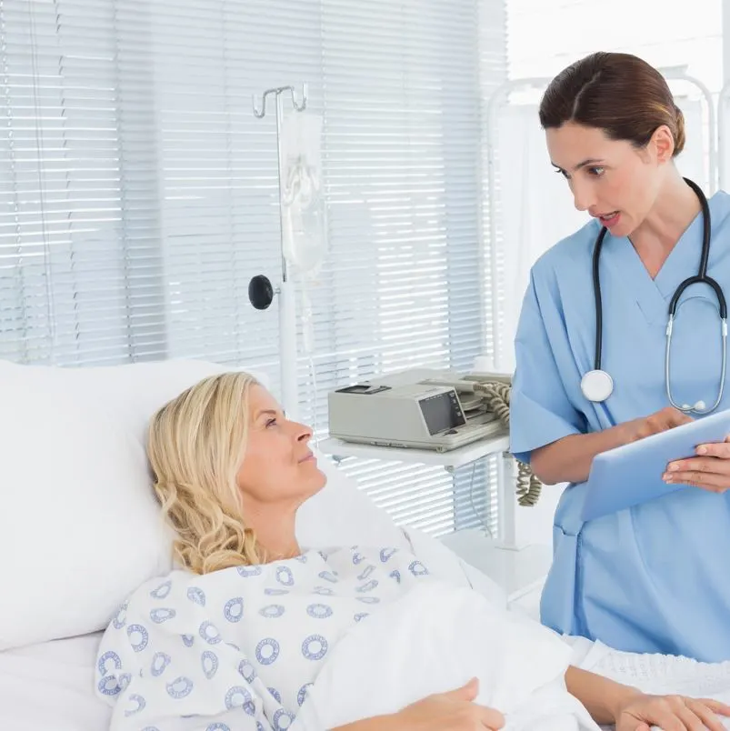 Women patient and doctor talking over her condition on a hospital bed