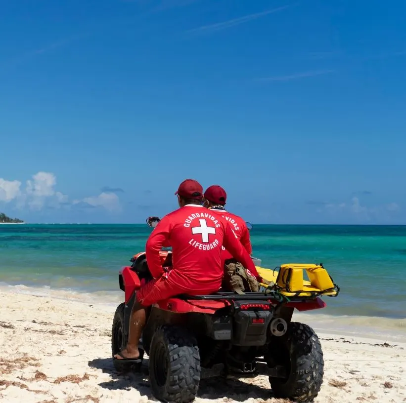 Two lifeguards on a quad bike at the waters edge