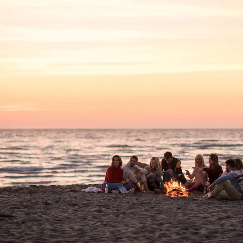 People around bonfire on a beach
