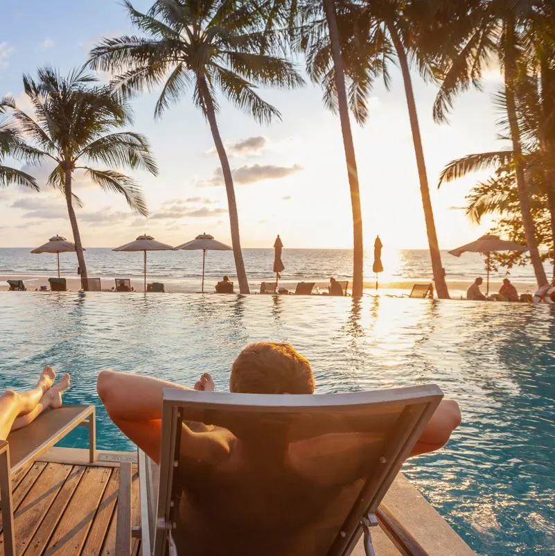 A man relaxing on a poolside sunlounger