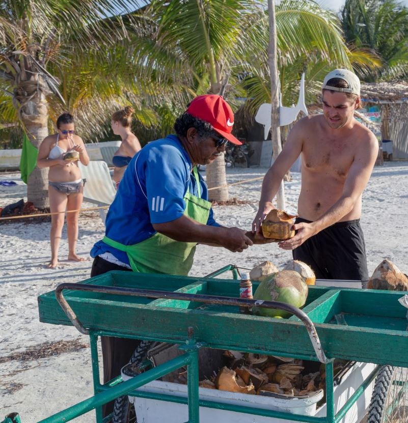 Vendor selling coconuts on a beach in Mexico