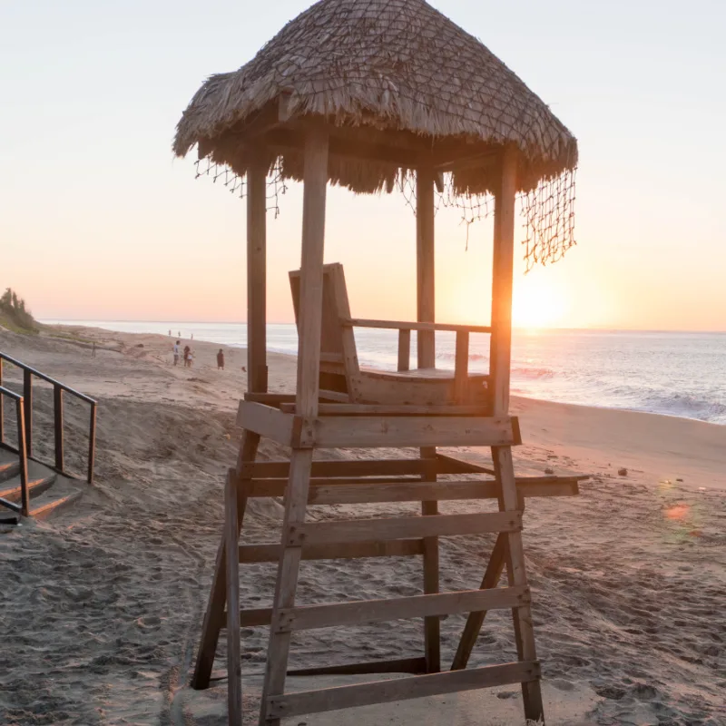 Lifeguard Chair on a Beach in Los Cabos, Mexico with Tourists Playing in the Background
