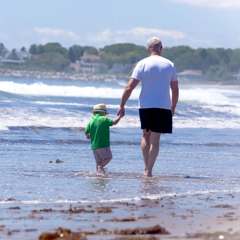 man and child walking down beach