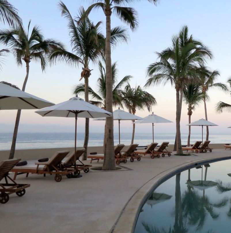 Resort Beach Chairs Beside A Pool Overlooking The Ocean