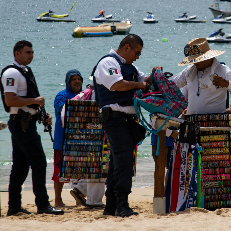 Los Cabos Police Checking the Bag of a Beach Vendor