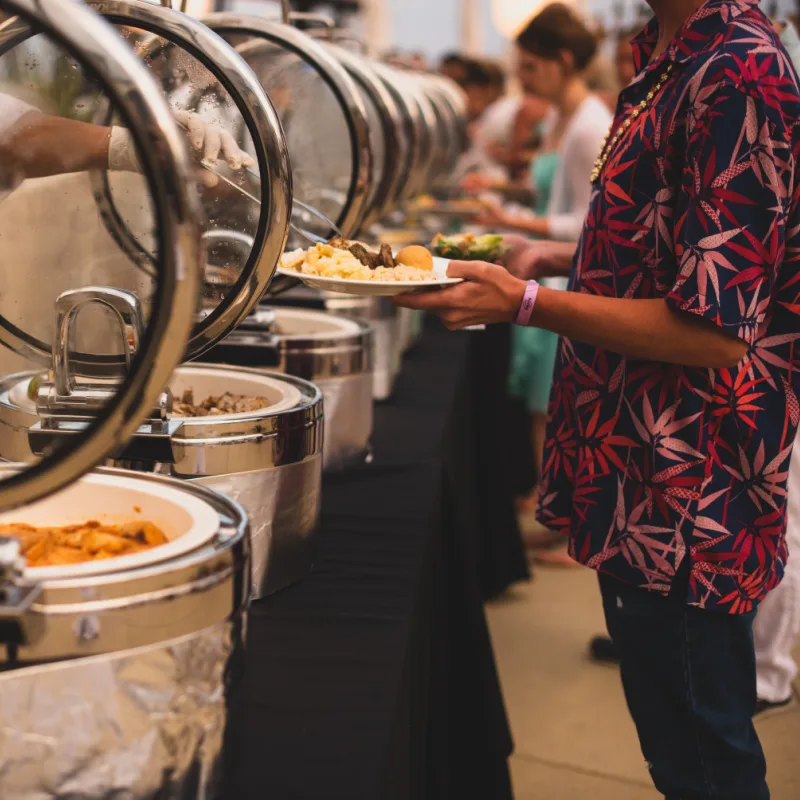 People Getting Food Out of Heated Containers at a Restaurant