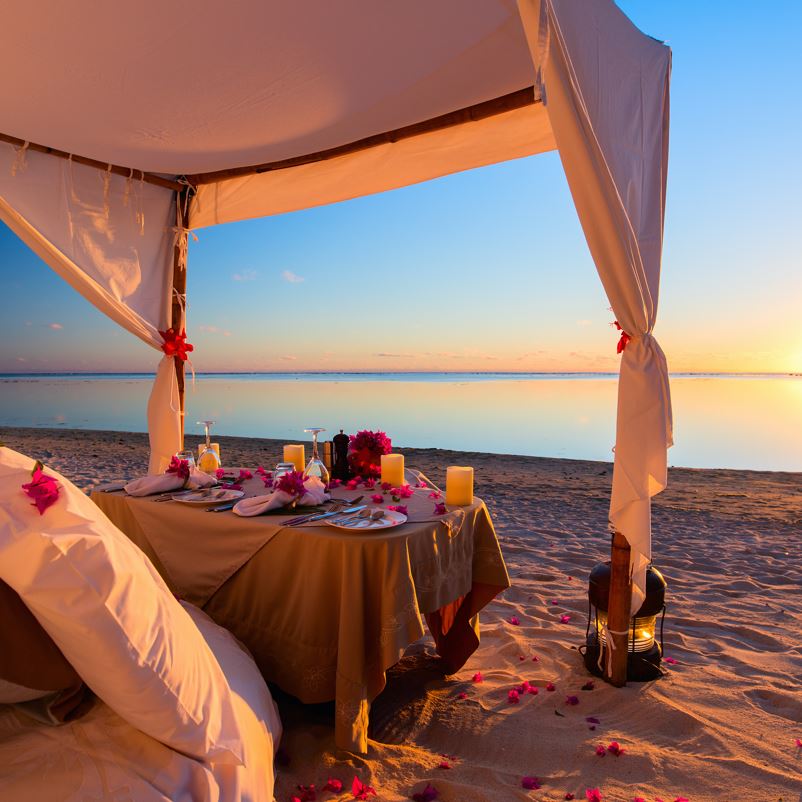 A romantic beach meal setting on a Los Cabos beach at dusk
