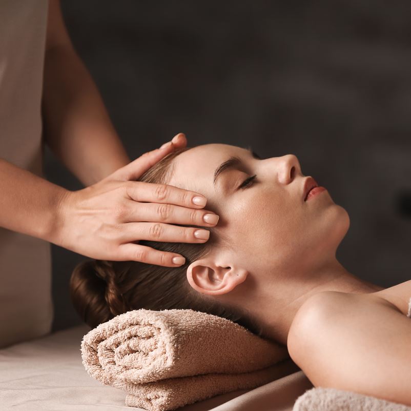 A woman receiving a head massage at a spa