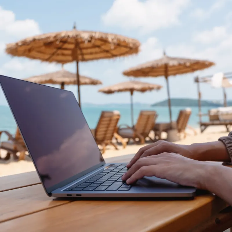 Woman working on laptop at beach