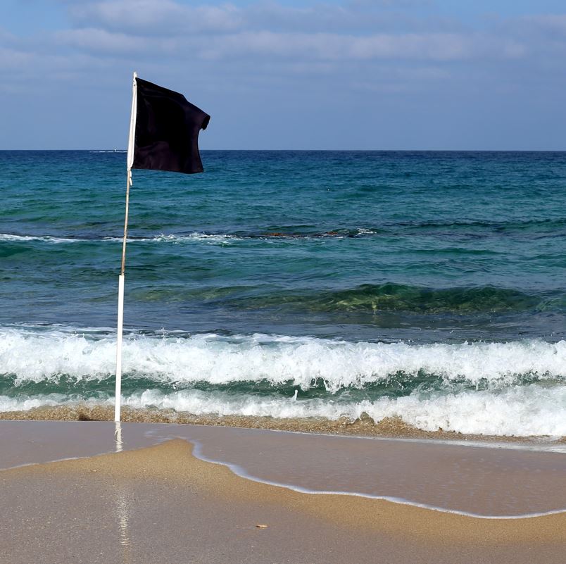black Flag waving on beach