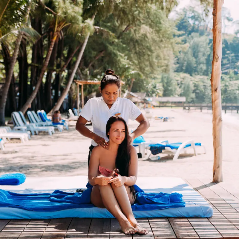 tourist enjoying massage at beach resort