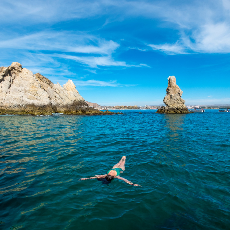 woman floating in ocean in cabo